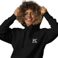 FL-FIT - Femme souriante portant un hoodie noir avec logo FL brodé, capuche relevée sur fond blanc